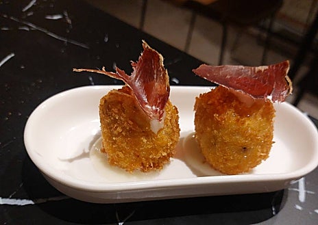 Imagen secundaria 1 - El neón de El Lince es el que tenía la casa de comidas que le da nombre, fundada en los años 60 en el mismo sitio. Las croquetas de cecina son uno de sus platos más pedidos, para acompañar las cañas o el vino. Al lado, Javi Estévez.