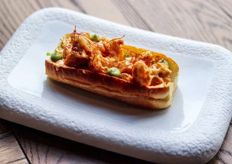 Imagen secundaria 1 - Sobre estas líneas, la empanadilla de ají. Abajo, a la izquierda, el 'lobster roll' de cigalas en tempura. A la derecha, el gofre de patatas bravas