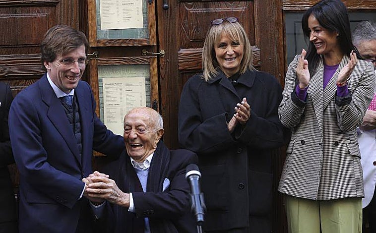 Imagen principal - Sobre estas líneas, Lucio Blázquez junto al alcalde de Madrid, José Luis Martínez-Almeida, su hija María Blázquez, y la vicealcaldesa Begoña Villacís, en Casa Lucio. Abajo, los cocineros Paco Roncero (izq.), Pepa Muñoz, Alberto Chicote, Sacha Hormaechea y Mario Sandoval durante el homenaje. A la derecha, la placa que luce desde este martes 7 de febrero en la fachada del restaurante.