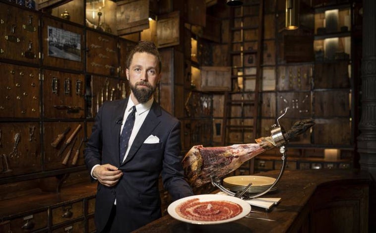 Imagen principal - El cortador Carlos Sánchez, mostrando uno de sus platos de minitapas de jamón