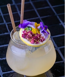 Imagen secundaria 2 - Arriba, la elegante y cálida sala de Terracott. Abajo, sus croquetas de carabineros con velo ibérico y su sangría cítrica y floral.