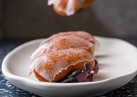 Imagen secundaria 1 - Arriba, la elegante y cálida sala de Terracott. Abajo, sus croquetas de carabineros con velo ibérico y su sangría cítrica y floral.