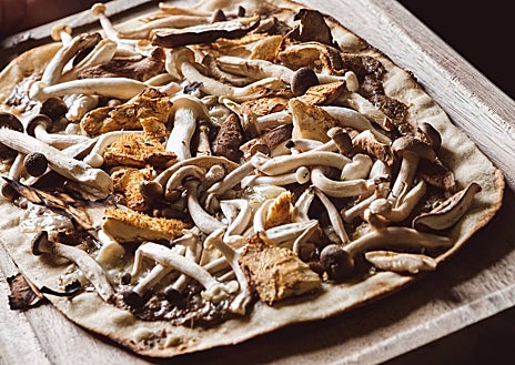 Imagen secundaria 1 - Sobre estas líneas, algunos de los platos de Moments. Las conchas abiertas en el josper son una de sus especialidades. Arriba, los mejillones 'cabreaos'. Abajo a la derecha, los berberechos. Al lado, una de la decena de cocas que ofrecen