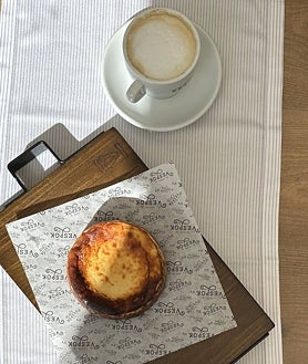 Imagen secundaria 2 - Sobre estas líneas, la terraza de El Rincón de Vespok, en la urbanización Puerta de Hierro de Madrid. Abajo, alguna de sus propuestas de picoteo y la tarta de quesos ahumados para dos que hornean al momento