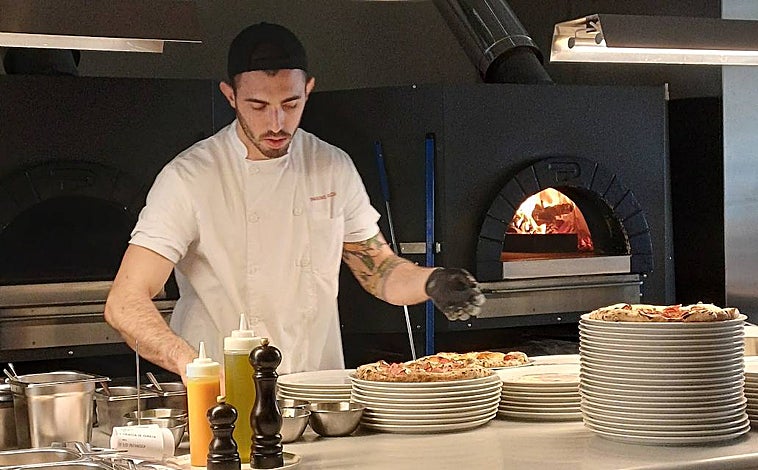 Imagen principal - Sobre estas líneas uno de los 'pizzaioli' del nuevo Parking Pizza de Madrid, en el paseo de la Castellana 89. Abajo, a la izquierda, una ración de 'bresaola' con virutas de apio, pimienta y ralladura de lima. A la derecha, 'rigatoni' con gorgonzola, queso 'taleggio' y salvia