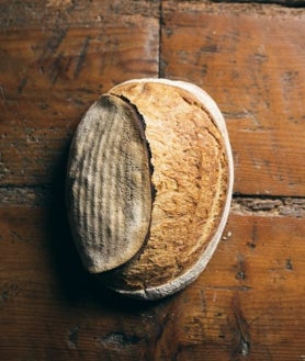 Imagen secundaria 2 - Jesús Sánchez y la panadera de Amós. Debajo, una de sus cestas y el pan de Amós, premiado este año como el mejor pan de restaurante.