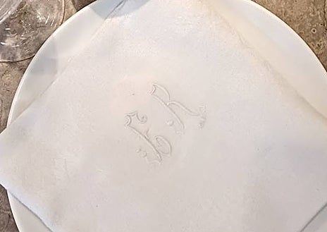 Imagen secundaria 1 - Sobre estas líneas, la cocinera riojana Lucía Grávalos. Abajo, detalle de las servilletas y los cubiertos recuperados de anticuarios franceses para los servicios de Desborre