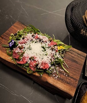 Imagen secundaria 2 - Varios platos de Showroom. En la foto general, el steak tartar sobre tuétano, la quinta costilla de vaca finlandesa al teriyaki y la torrija. Abajo, de nuevo el steak tartar y el carpaccio.