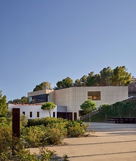 Imagen secundaria 2 - Sobre estas líneas , la cama instalada en las antiguas cocinas de elBulli. Abajo, las vistas a Cala Montjoi desde la terraza del antiguo restaurante y las vistas del complejo museístico desde el exterior.