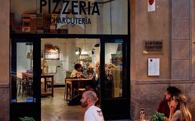 Imagen principal - Sobre estas líneas, el local de Sartoria Panatieri en Eixample. Abajo, a la izquierda algunos de los platos que acompañan su oferta de pizzas. A la derecha, su horno de leña