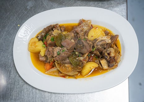 Imagen secundaria 1 - Sobre estas líneas, arriba, Gustavo Astrada (derecha) junto con Blas Rodríguez de La Mamma. Abajo, a la izquierda, guiso de carne de cabra en Casa Marcos. Lapas con mojo verde en El Roque de los Pescadores