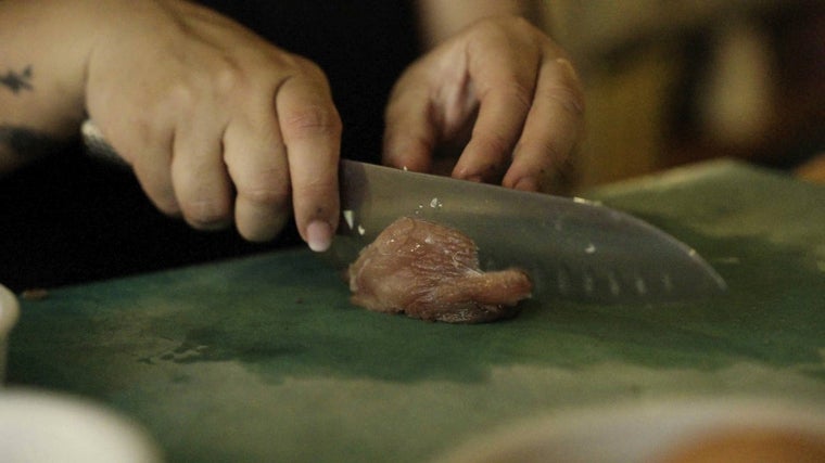 La chef haciendo cortes en rodajas de bonito