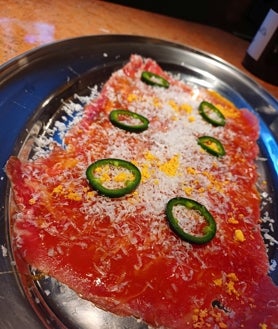 Imagen secundaria 2 - Sobre estas líneas, chipirones en su tinta, la tabla de charcutería y quesos y el carpaccio de vaca con parmesano y aceite picante de Martín Tostón