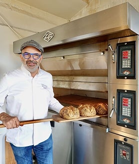 Imagen secundaria 2 - La sala y la terraza de Amós, en Madrid, y el chef Jesús Sánchez en su panadería de Cantabria.
