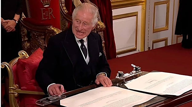 Carlos III en el momento de la firma