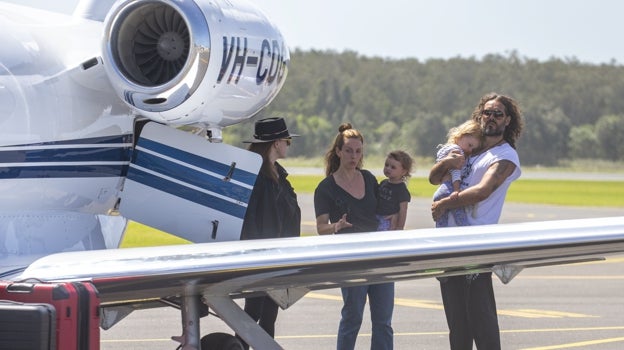 Russell junto a sus dos hijas Mabel y Peggy subiendo a un jet privado