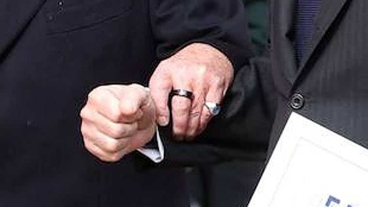 Detalle de la mano de Juan Carlos I, agarrada del brazo de su hijo