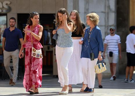 Imagen secundaria 1 - Arriba, la Princesa Leonor conduciendo un coche gris acompañada por su madre, su hermana y su abuela paterna. Izquierda, las cuatro posando ante los medios. Derecha, visitando una de los puestos de ropa.