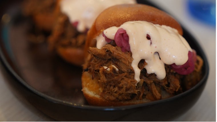 Pan bao semidulce frito con cerdo asado, cebolla encurtida y spicy mayo