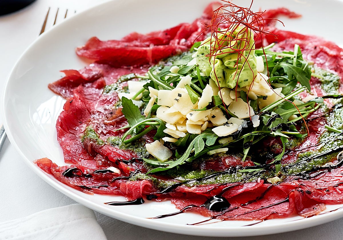 Tostada de carpaccio, hummus de remolacha, rúcula y brotes de soja