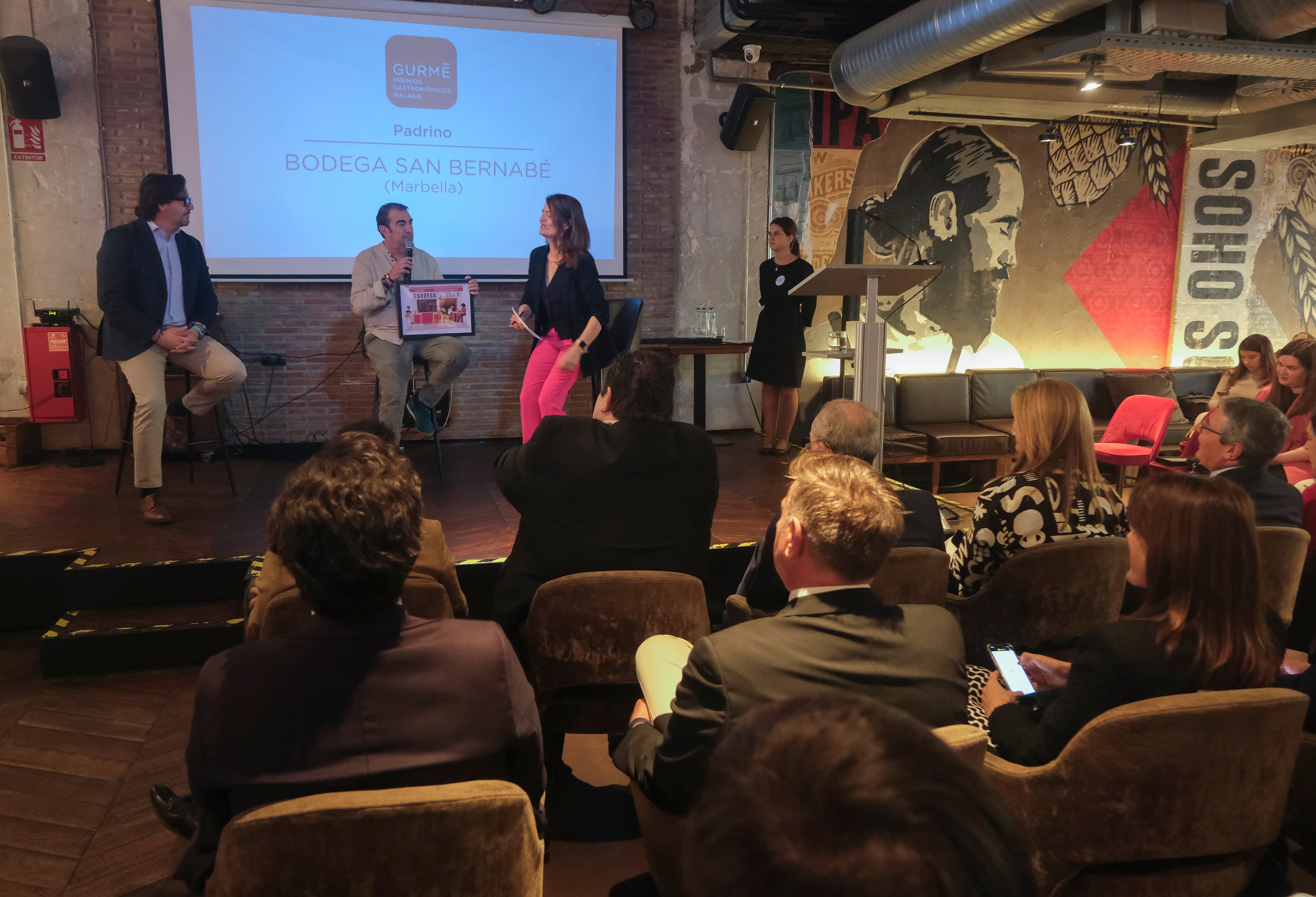 Álvaro Blanco, de Bodega San Bernabé, recogiendo su premio de Padrino junto a Isabel Aguilar, Coordinadora de GURMÉ, y Rafael Méndez, Área Manager de Heineken en Málaga