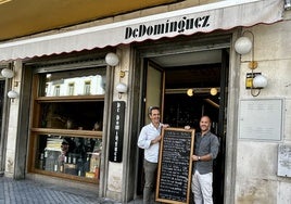 Lucas Bernal y Javier Padura, sujetando el cartel de tapas de De Domínguez