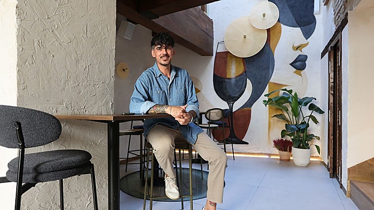 Eduardo Puya, sentado ante el mural de la planta baja de la céntrica taberma