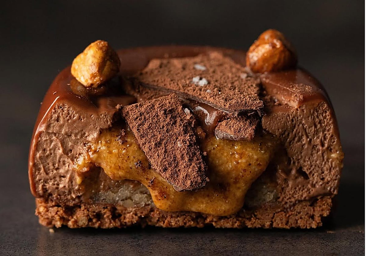 Royal de chocolate, con base crujiente de chocolate, bizcocho de almendra y avellana, mousse de chocolate al 55%, praliné fluido de avellana y almendra, y flor de sal, de Sueño, en Málaga