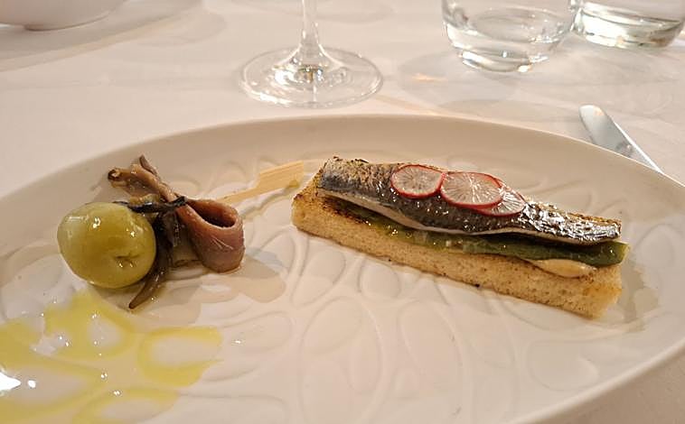 Imagen principal - Gilda de gordal sevillana con anchoa y piparra, que viene acompañada de una sardina soasada sobre tosta de ajo frito serrano; tomate de Cal Viva con salmorejo de su aliño; y Leo Ramos, chef y sumiller