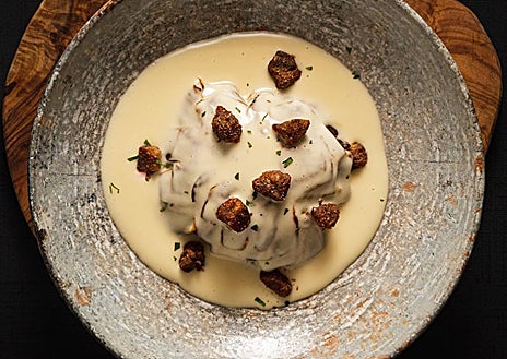 Imagem Secundária 1 - Javier Fabo em sua cozinha montando pilpil, flor de alcachofra com manteiga de xerez e torresmo de porco ibérico, e uma das mesas do restaurante Amara.