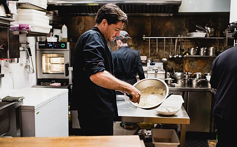 Imagem principal - Javier Fabo em sua cozinha montando pilpil, flor de alcachofra com óleo de xerez e torresmo de porco ibérico, e uma das mesas do restaurante Amara.