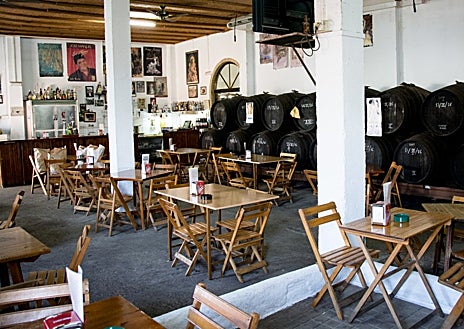 Imagen secundaria 1 - Potaje de garbanzos, salón interior con los barriles y plato de jamón ibérico de la bodega Pepe Girón, en Bormujos