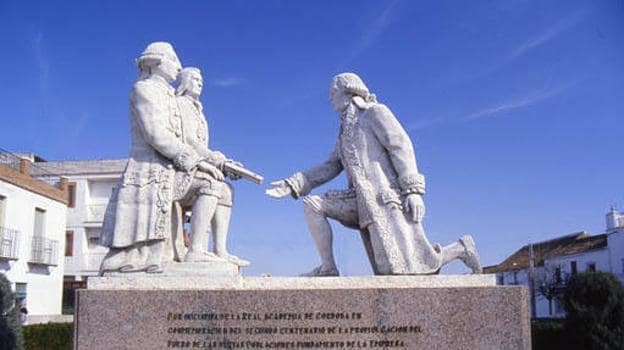 Carlos III, frente a Olavide, arrodillado. Monumento en el municipio de La Carlota.