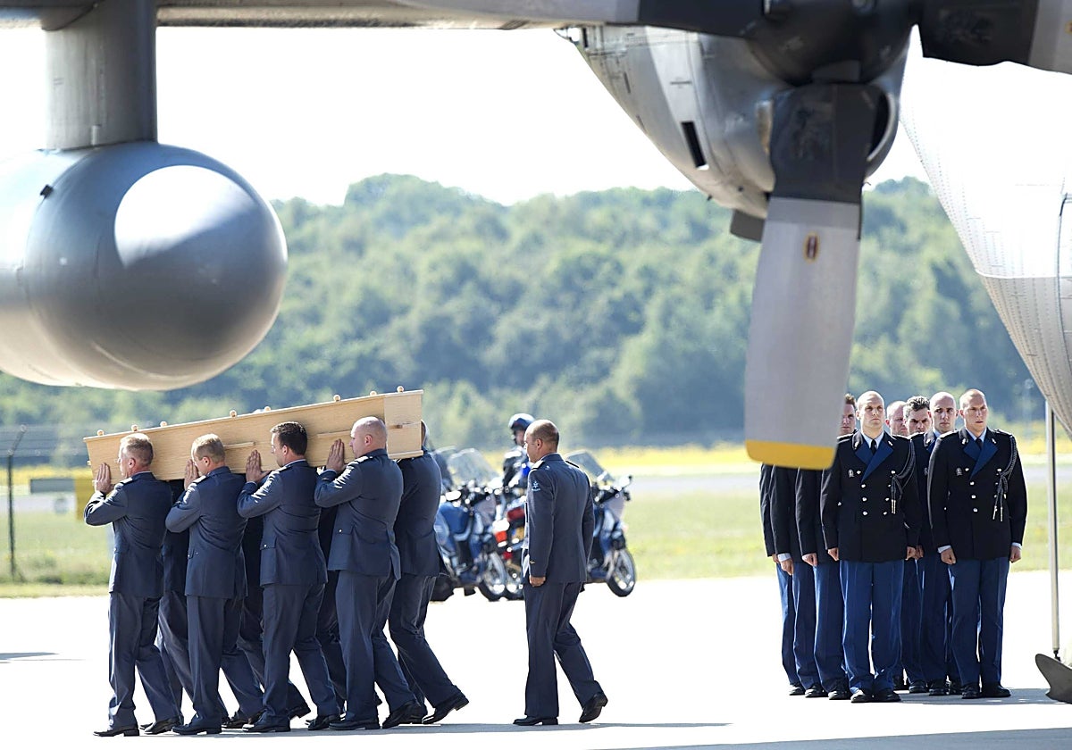 Varios soldados se dirigen a introducir un ataúd con los restos de una víctima del vuelo MH17 de Malaysia Airlines