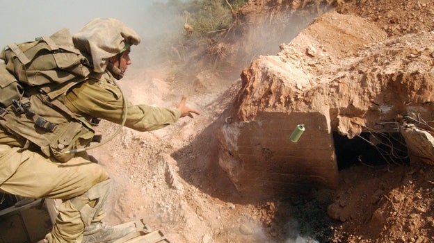 Un soldado de las FDI lanza una granada de humo en un búnker de Hezbolá