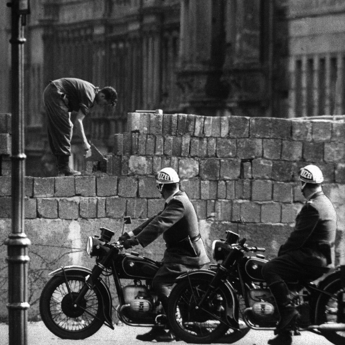 Fotografía de archivo tomada en agosto de 1961 que muestra a varios obreros levantando el muro en la calle Bernauer en Berlín