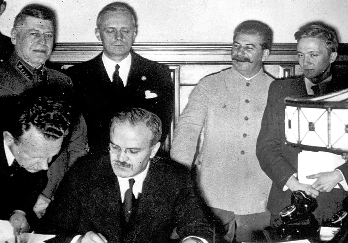 Molotov firma el acuerdo sobre delimitación de las fronteras polacas entre Alemania y Rusia. Detrás Von Ribbentrop y Stalin