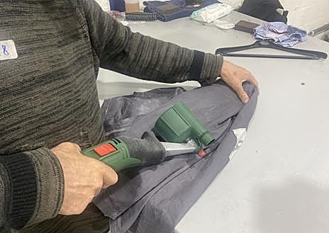 Imagen secundaria 1 - Alberto Luna revisa varias prendas. Abajo, a la izquierda, lijado de una prenda en la sala de ambientación. A su derecha, varios objetos que completan la vestimenta