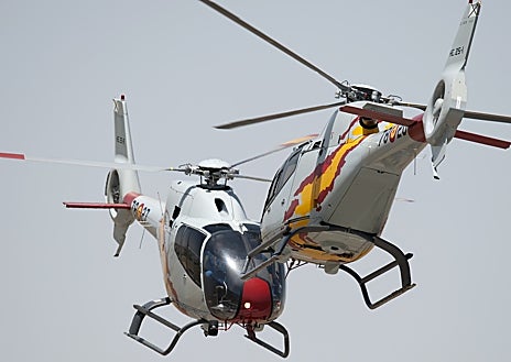 Imagem Secundária 1: Implantação de helicópteros Colibrí em aeronave A400M. Abaixo: Dois helicópteros da Patrulha Aspa durante a exposição. Ao lado dele está o capitão Gabriel Navarro de Castro.