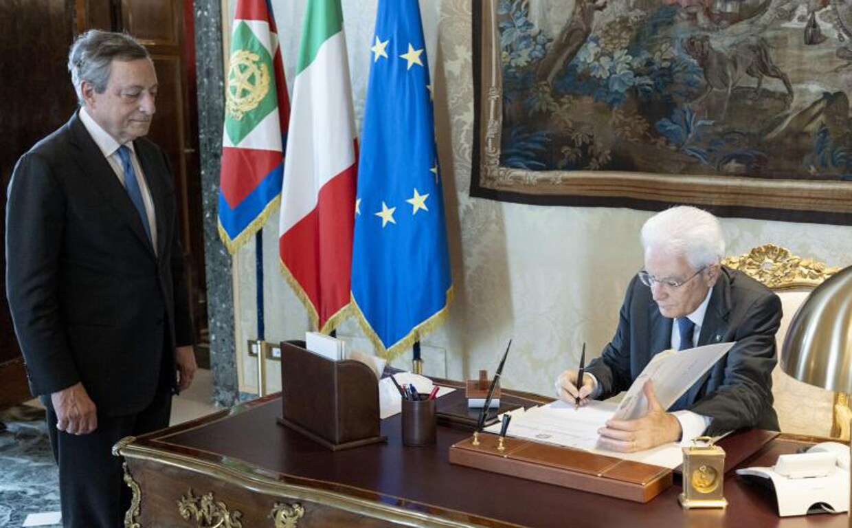 El presidente italiano, Sergio Mattarella, firma la discreción para disolver el Parlamento frente a Mario Draghi