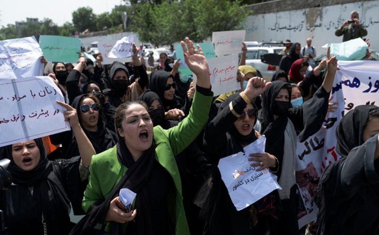 Mujeres afganas sostienen pancartas mientras marchan y gritan lemas en Kabul