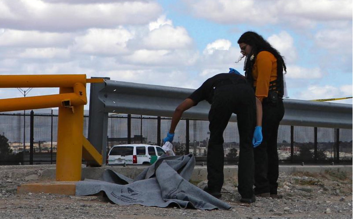 Peritos forenses inspeccionan el cuerpo de una niña migrante guatemalteca que se ahogó al intentar cruzar con su madre el Río Bravo hacia Estados Unidos