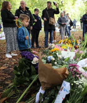 Imagen secundaria 2 - Arriba, Erik Karlsen con sus empleados, Roaika y Aleksander, en Pulbrook & Gould. Debajo, dos aspectos de Green Park, donde se están acumulando los ramos en memoria de Isabel II