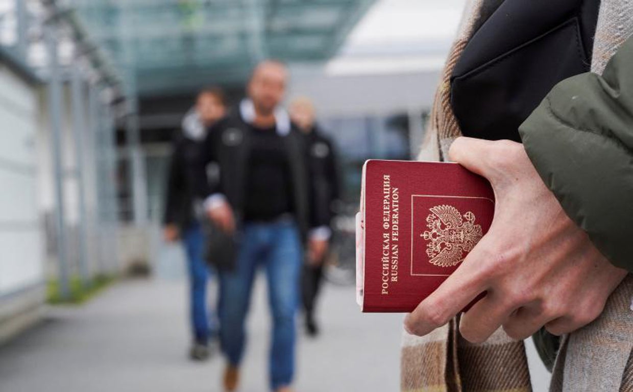 Una persona sostiene un pasaporte ruso en el cruce fronterizo entre Rusia y Finlandia