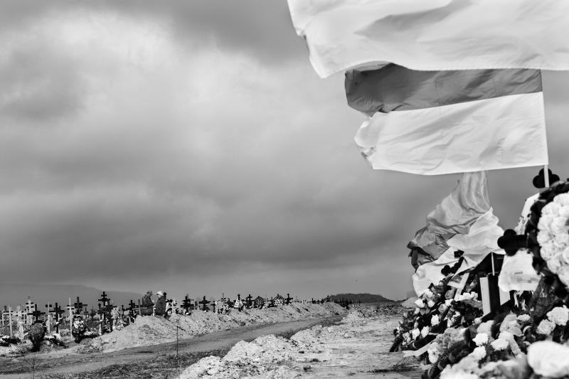 Un hombre y una mujer caminan entre las tumbas de los civiles que han fallecido en esta región desde que comenzara la invasión rusa el pasado 24 de febrero. Las sepulturas están situadas junto al cementerio militar de Matviyivka, en Mykolaiv. A la derecha, banderas y coronas de flores decoran el lugar donde reposan los soldados caídos en combate. Es difícil encontrar familias en Ucrania que no hayan perdido un familiar o conocido en el frente