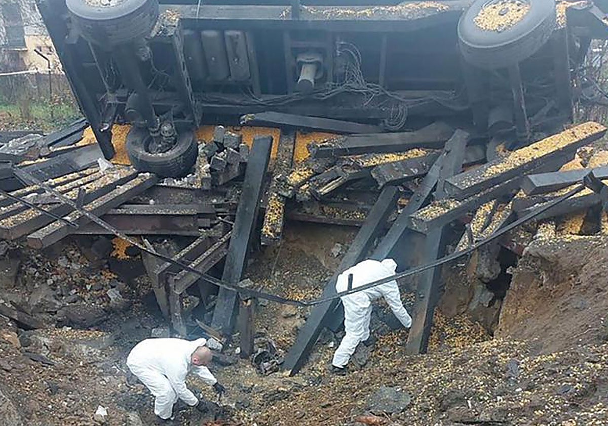 Dos forenses investigan en el cráter provocado por el misil que cayó en la localidad de Przewodow