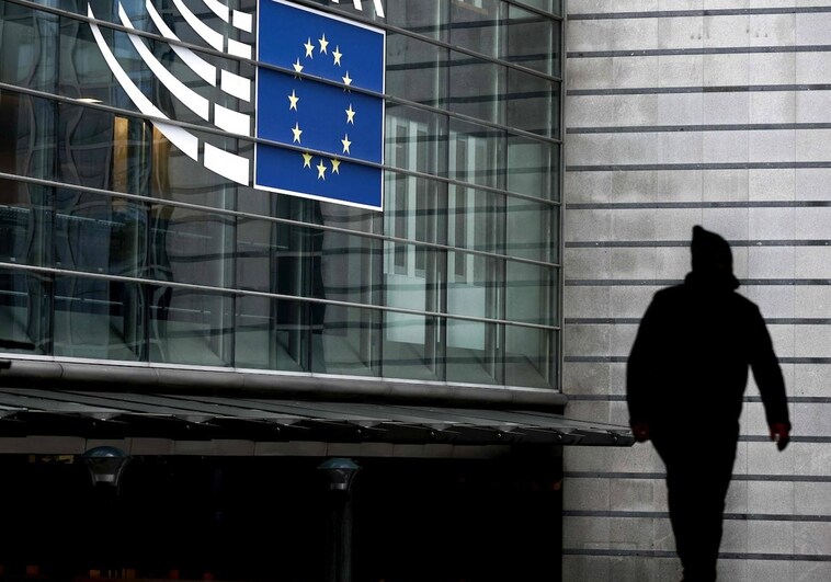 A man passes in front of the entrance to the European Parliament