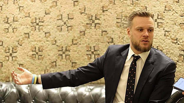 Gabrielius Landsbergis gesticula y muestra en su mano derecha dos pulseras con los colores de la bandera de Ucrania