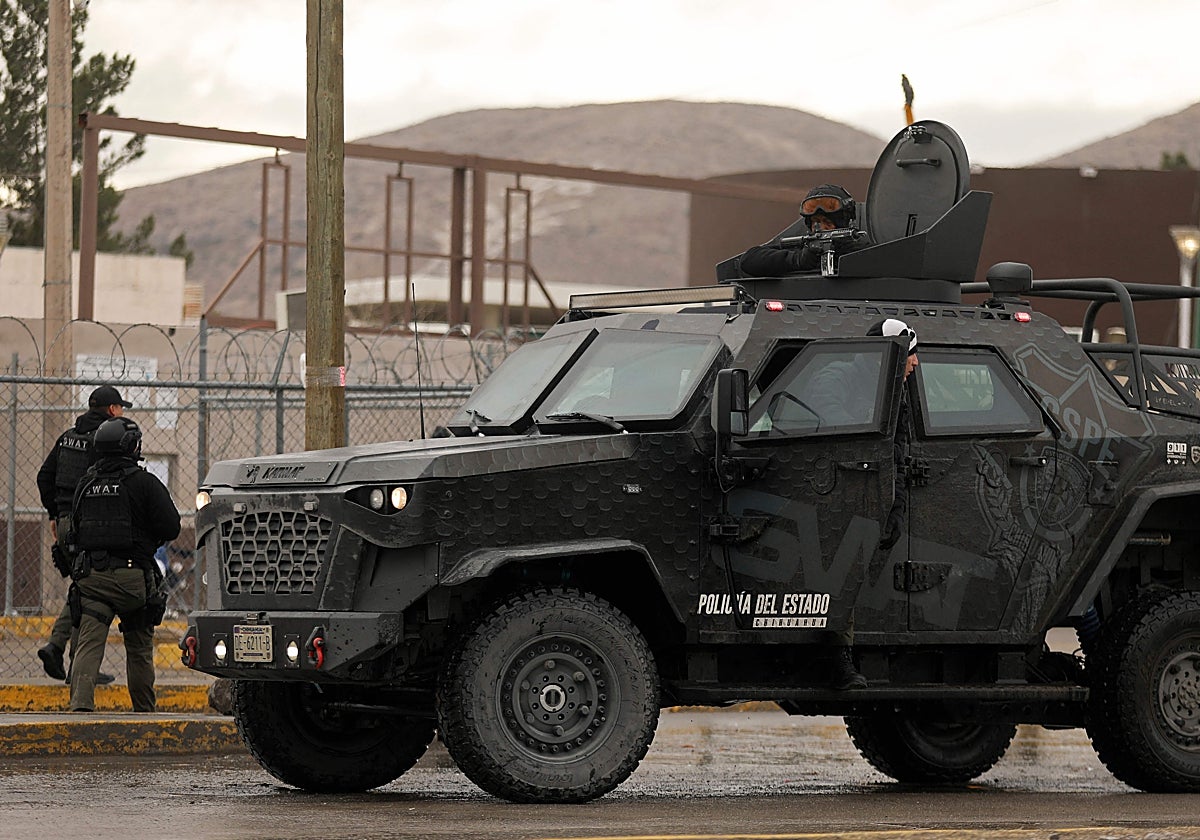 Policías estatales de Chihuahua a bordo de un vehículo blindado aseguran una zona a las afueras del penal número 3 de Ciudad Juárez, en Ciudad Juárez
