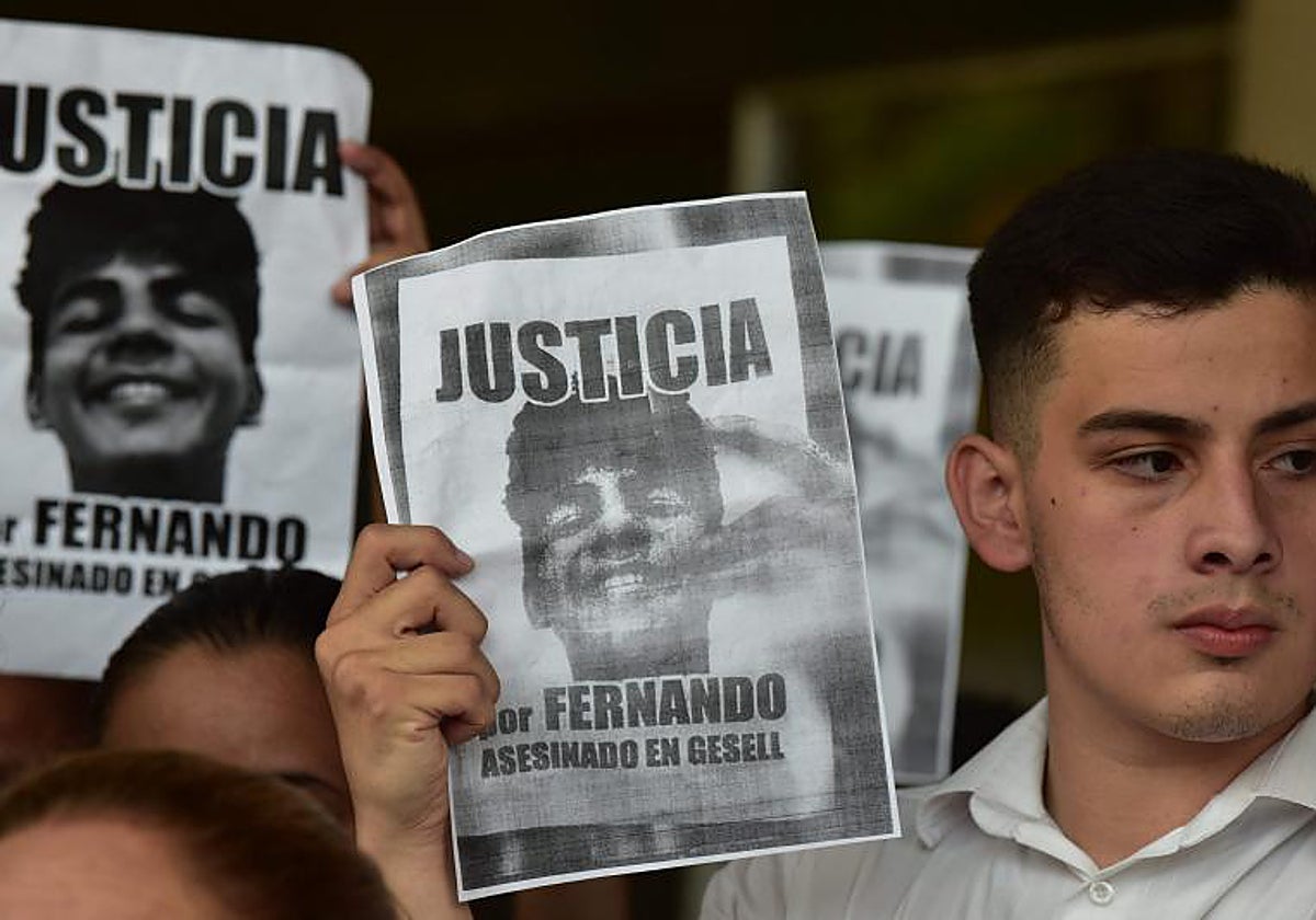 Un hombre sostiene un cartel con un retrato del argentino Fernando Báez Sosa, un adolescente asesinado a golpes hace tres años en Villa Gesell, Argentina, que dice «Justicia para Fernando».